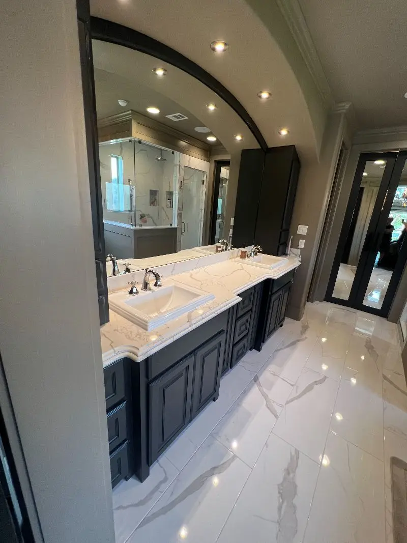 Luxury master bathroom with Calacatta marble vanity arched mirror and polished marble floors in Manvel TX