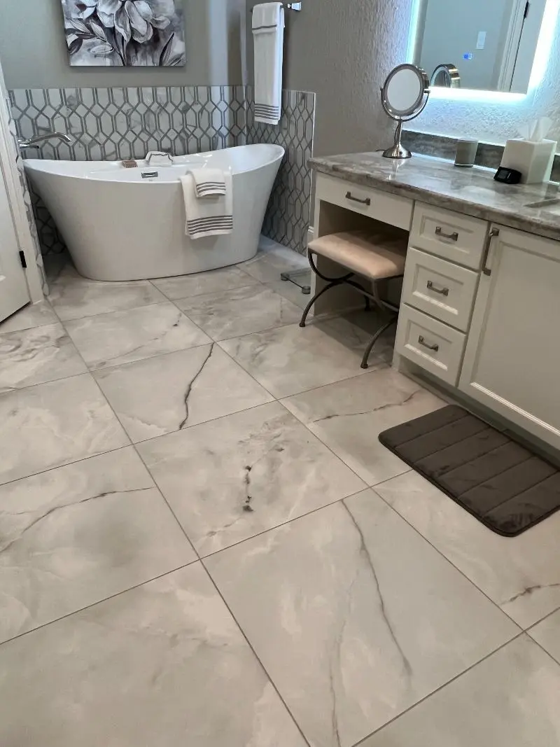 Master bathroom with freestanding tub geometric tile accent marble floors and makeup vanity in Friendswood TX