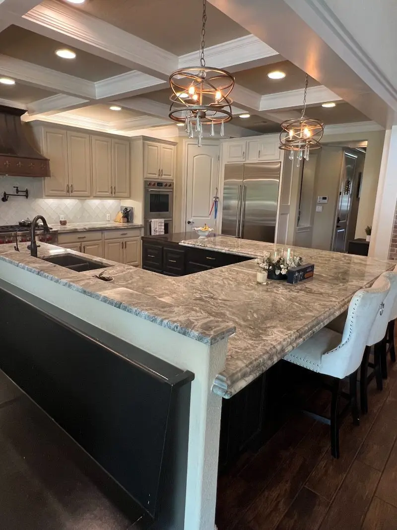 Luxury kitchen with gray granite island coffered ceiling and orb chandeliers in League City TX