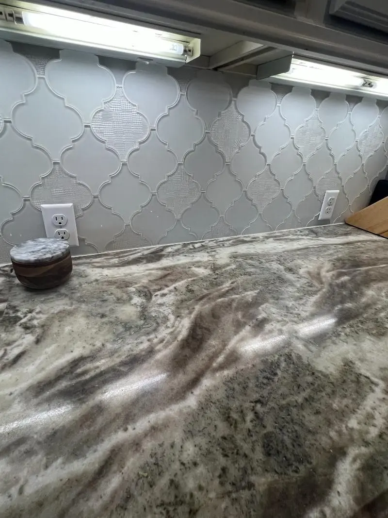 Exotic granite countertop with arabesque tile backsplash and under cabinet lighting in Dickinson TX