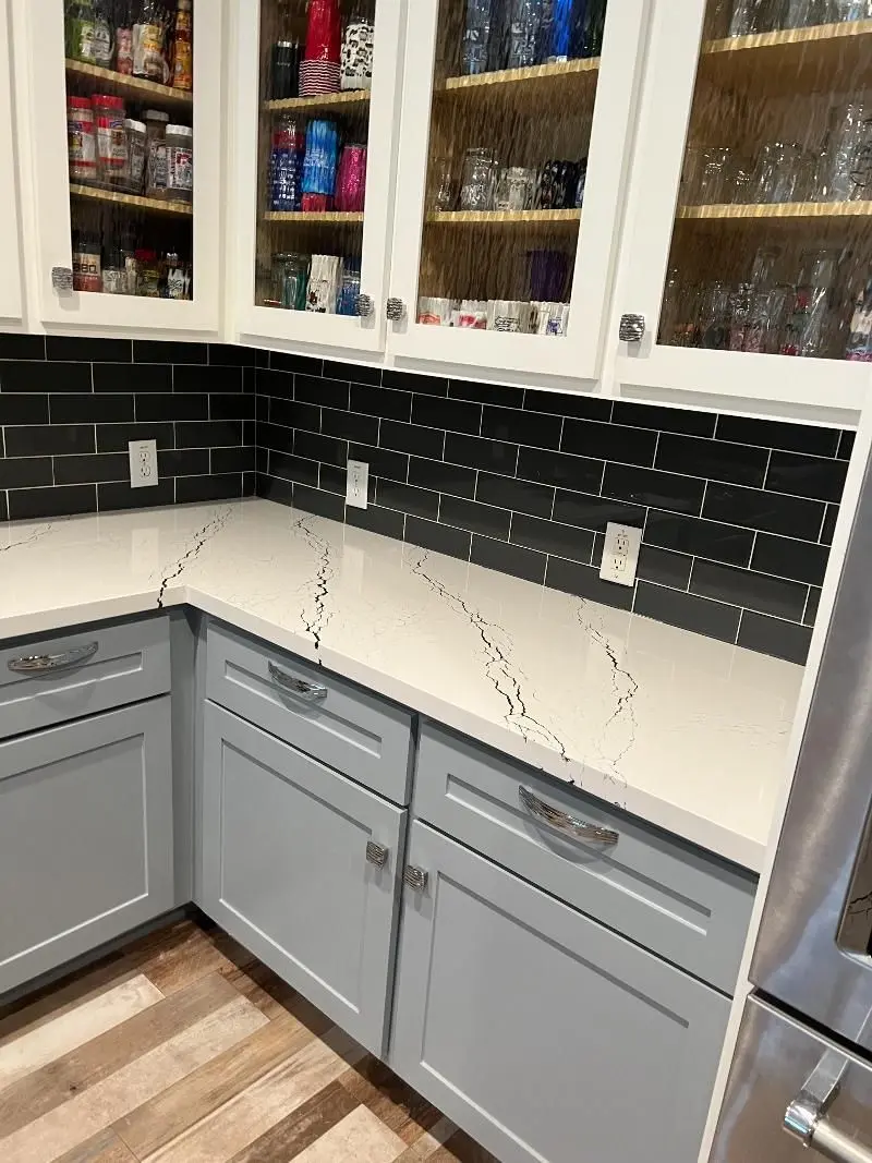 White quartz countertops with black subway tile backsplash and gray cabinets in Pearland TX
