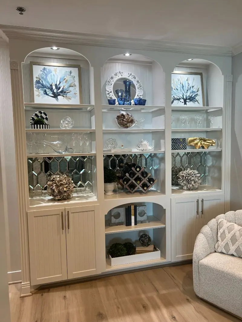 Custom arched built-in shelving with mirror tile backsplash wine storage and coastal decor in Santa Fe TX